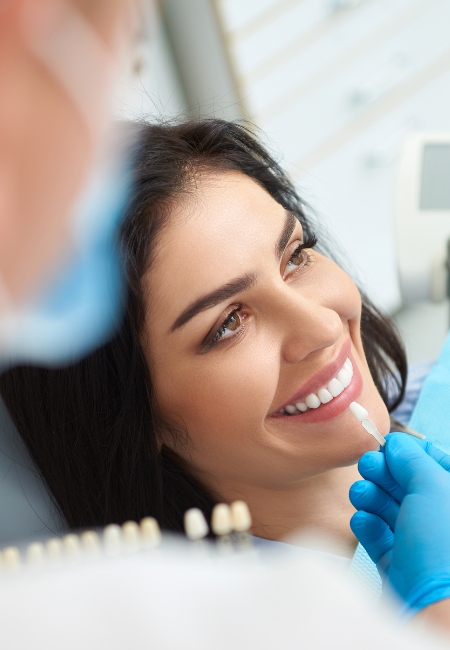 A smiling woman receives a dental check-up