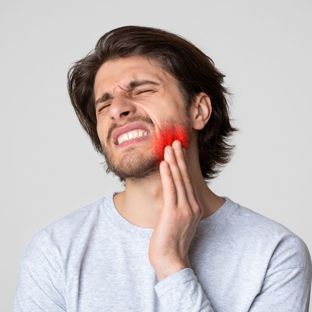 A man holding his cheek in pain